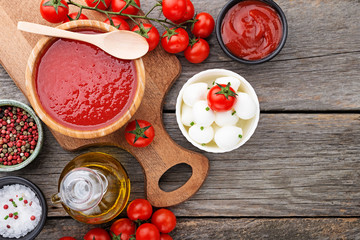 Ingredients for cooking - tomato sauce, pasta, tomatoes, garlic, olive oil on the old wooden background. top view.