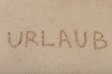 Schrift im Sand mit Schneckenhäusern