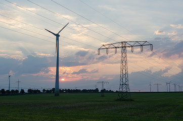 Windräder und Strommasten auf landwirtschaftlicher Fläche