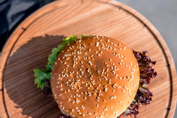 top view of the beef burger on wooden plate, on the street, outdoor, fast food