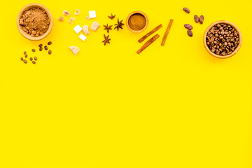 Fototapeta premium Flavouring products for making desserts. Cinnamon, cocoa, coffee on yellow table top view space for text