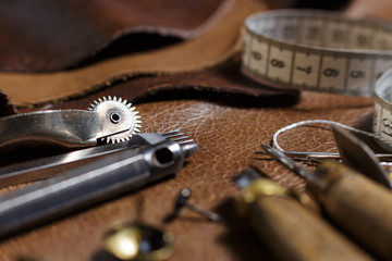 Furniture assembly components and tools, cow leather samples in the in the craftman's workshop.