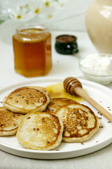 Linen pancakes served with honey and cream cheese on a light background. Rustic style.