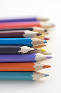 Close up of wooden colorful pencils, group of scattered crayons, isolated od white background