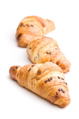 Three croissants with chocolate crumbs.
