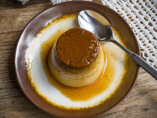 Flan in a plate on wood background