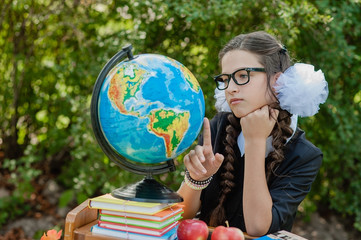 Portrait of a beautiful young first-grader sitting at a desk