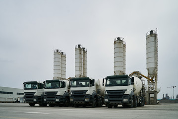 Concrete factory with silos and trucks. Concrete mixing silo, site construction facilities. Industry manufacturing concept