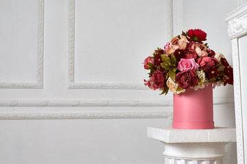 Big bouquet of flowers on the column./A large bouquet of flowers on a column in the lobby.