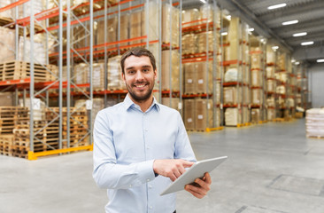 logistic business, technology and shipment concept - happy businessman with tablet pc computer checking goods at warehouse