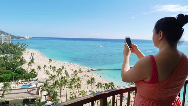 Professional video of woman taking picture of Waikiki beach in Hawaii in 4K slow motion 60fps