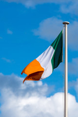 national flag of Ivory Coast blowing in the wind with blue sky in background