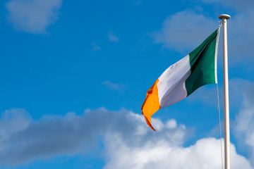 national flag of Ivory Coast blowing in the wind with blue sky in background