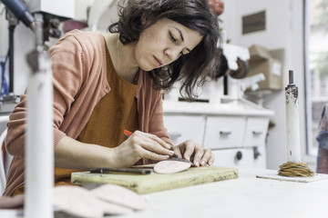 Woman designer making handmade shoes in her workshop