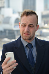 confused businessman with smartphone