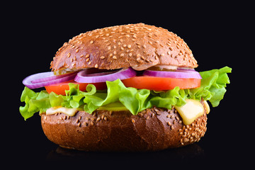 Fresh tasty burger isolated on black background. Tasty and appetizing cheeseburger. Vegetarian burger