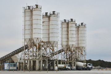 Concrete factory with silos and trucks. Concrete mixing silo, site construction facilities....