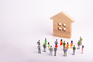 A crowd of people standing and looking at a wooden house on a white background. Buying and selling...
