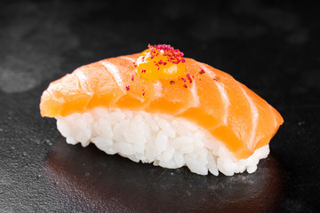 Sushi nigiri with salmon on black background
