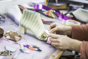 Woman designer making handmade shoes in her workshop