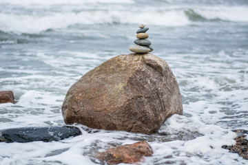 Stacked Stones on top of a huge stone in the ocean