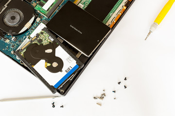 Hdd disk and solid state drive over disassembled notebook at electronic service center. Replacement...