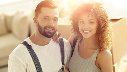 Happy married couple on the background of a new apartment
