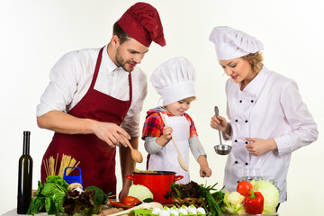 Happy family in kitchen. Healthy food at home. Parents with child preparing dinner. Child with parents cooking at kitchen table. Homemade food. Isolated on white background.