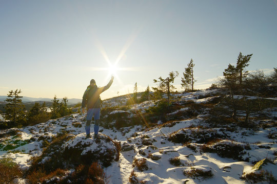 A man touching and lighting up the sun.