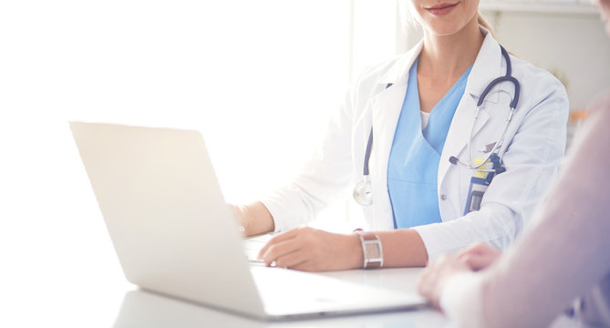 Doctor and patient couple are discussing something,sitting on the desk.