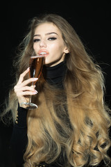 Sensual romantic blonde model in black clothes with long healthy hair enjoying champagne. Passionate sexy woman with gorgeous long hair, perfect makeup, sexy sensual lips, drinks champagne.Luxury look