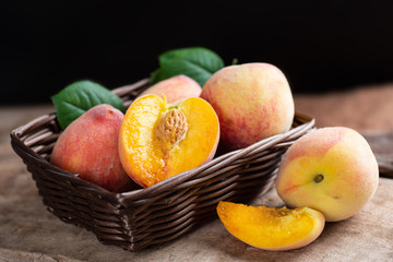 Ripe peaches in a basket on wooden, tropical fruit