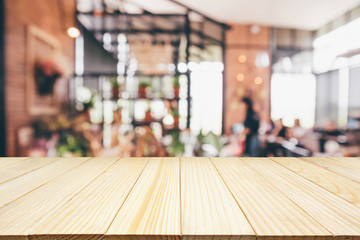 Wood table with Restaurant cafe or coffee shop interior with people abstract defocused blur background