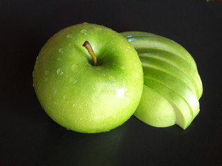 Green apple and cut apple isolated on a black background