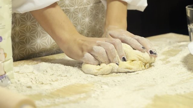 Girl kneads the dough for cookies