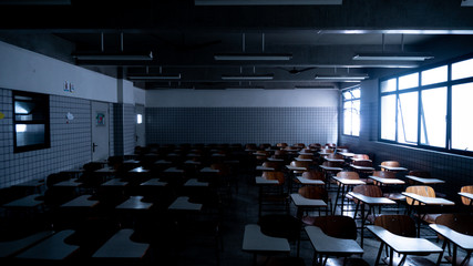 Empty classroom illuminated by some shiny windows - obrazy, fototapety, plakaty