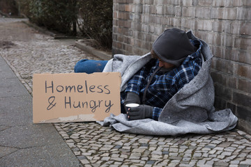 Male Beggar Lying On Street