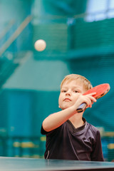boy plays flying table tennis ball in the tennis hall