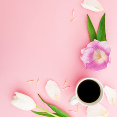 Composition with tulip flowers, petals and mug of coffee on pink background. Flat lay, top view.