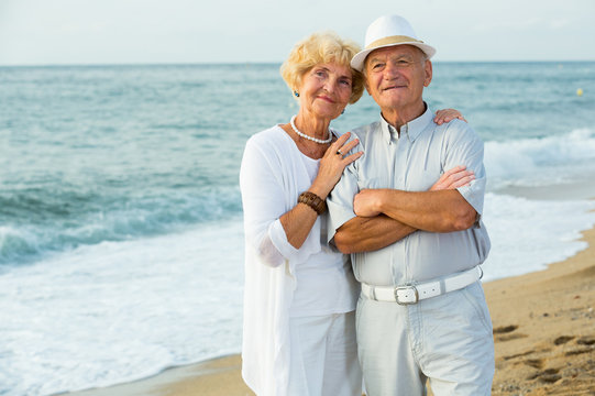 happy pensioners woman and man on the beach
