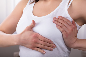 Fototapeta na wymiar Close-up Of A Woman's Hand On Breast