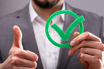 Businessperson Holding Check Mark Icon