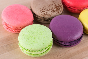 many multicolored cakes on a wooden plank background