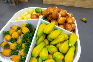 Plastic fruits on model supermarket shelf. Children pay toys