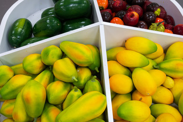 Plastic fruits on model supermarket shelf. Children pay toys