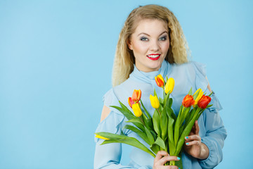 Pretty woman with red yellow tulips bunch