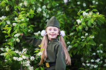 Sweet girl in a military uniform with a bouquet of apple blossom