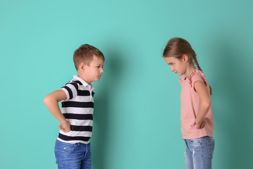 Brother arguing with sister on color background