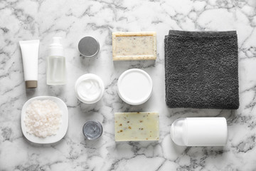 Flat lay composition with spa cosmetics and towel on light background