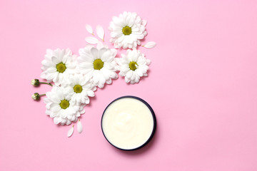 cream for care on a pastel background with a floral composition in the style of minimalism. view from, design.